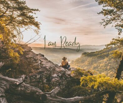 Text: I am ready against a background picture of a blonde girl with a hat sitting on a cliff overlooking mountains